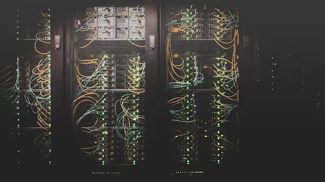Rows of server racks plugged into large industrial transformers and power conduits